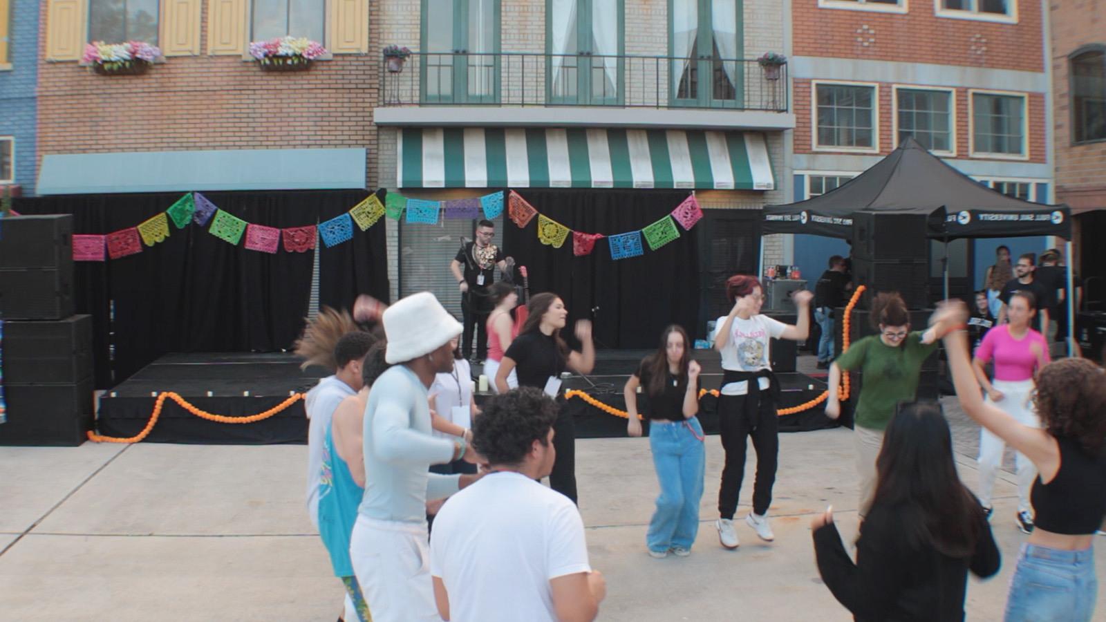 A group dancing at the Latin Music Festival hosted at the Full Sail Backlot.