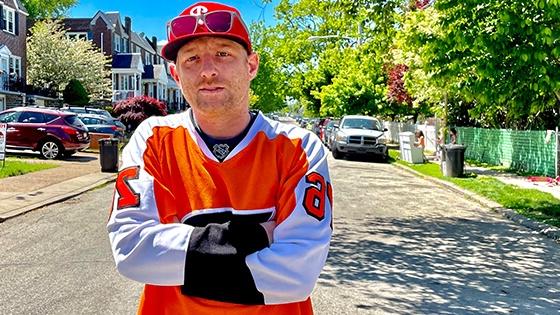 满帆 电影 Production MFA grad Panda Lord in an orange hockey jersey on a residential Philadelphia street.