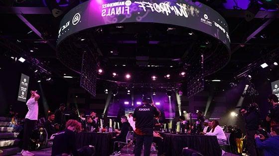 The Full Sail University Orlando Health Fortress esports arena’s main stage and large screens feature Jump Off’s purple and white branding while competitors face-off at gaming stations.