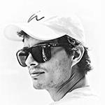 A black and white photo of Matias from the neck up, wearing a pair of sunglasses with dark frames while looking into the distance.