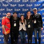 Armada graduates Nathan Duke and Megan Danaher and Full Sail esports staffers Sari Kitelyn, Bennett Newsome, and Jacob Kaplan stand in front of a NACE backdrop.