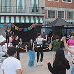 A group dancing at the Latin 音乐 Festival hosted at the 满帆 Backlot.